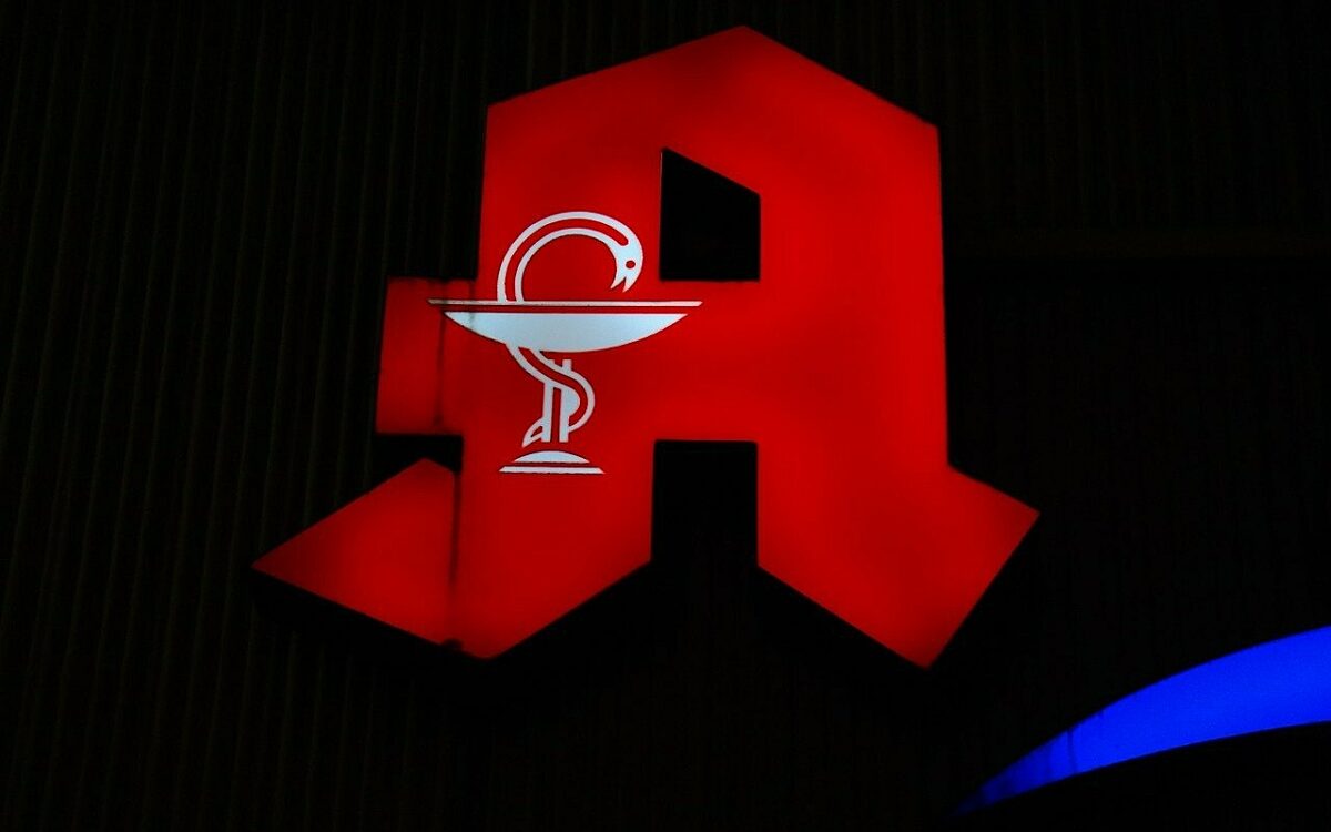 Man sieht das beleuchtete "A" einer Apotheke in der Nacht Man sieht das beleuchtete "A" einer Apotheke in der Nacht
